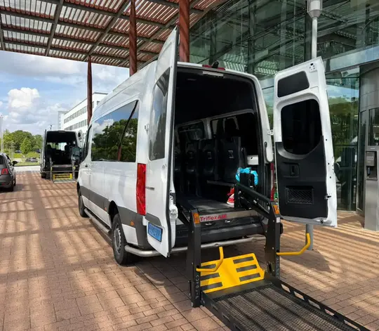 Professionele rolstoeltaxi chauffeur helpt klant in Leiden